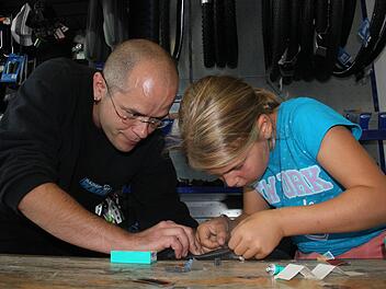 Christian Weiß zeigt der neunjährigen Amelie, wie man das Reparaturpflaster aufklebt. Fotos: Max Kaltenhäuser