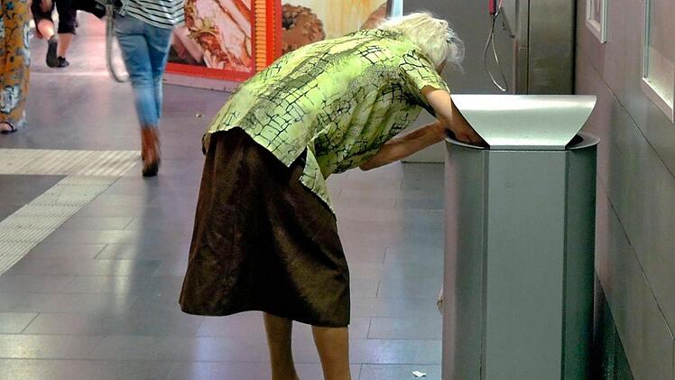 Eine alte Frau sammelt Flaschen aus einem Abfalleimer am Hauptbahnhof in Mülheim. Nach einer aktuellen Studie droht immer mehr Rentnern der Absturz in die Armut. Die Diakonie fordert am Montag (26. Juni) eine Mindestrente. Symbolfoto: epd