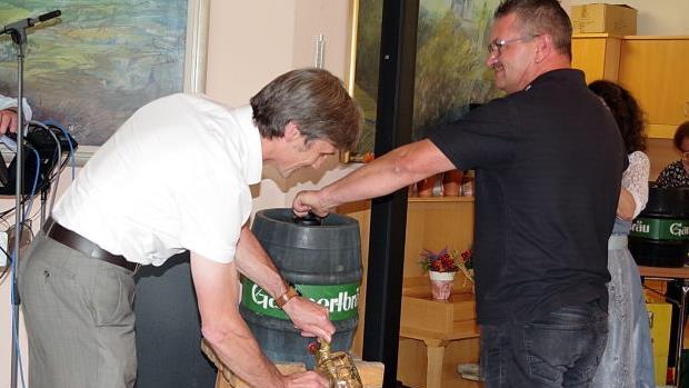 BRK-Kreisgesch&auml;ftsf&uuml;hrer Roland Beierwaltes (l.) und Hausmeister Tobias Heller beim Bieranstich f&uuml;r das Oktoberfest der Senioren. Foto: Heike Sch&uuml;lein