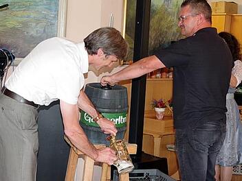 BRK-Kreisgeschäftsführer Roland Beierwaltes (l.) und Hausmeister Tobias Heller beim Bieranstich für das Oktoberfest der Senioren. Foto: Heike Schülein