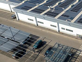 Luftaufnahme eines Warenlagers bei Nacht. Auf dem Parkplatz stehen zahlreiche Lagerhallen und Lastwagen mit Anh&auml;ngern, die darauf warten, beladen zu werden, um die Waren im ganzen Land weiterzuverteilen. Aerial view of a Lidl supermarket chain. Bari, Italy - September, 2024