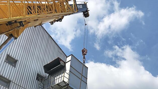 Die Etikettieranlage wird von einem Kran vorsichtig in die Flaschenabf&uuml;llerei der Gampert-Br&auml;u gehoben.