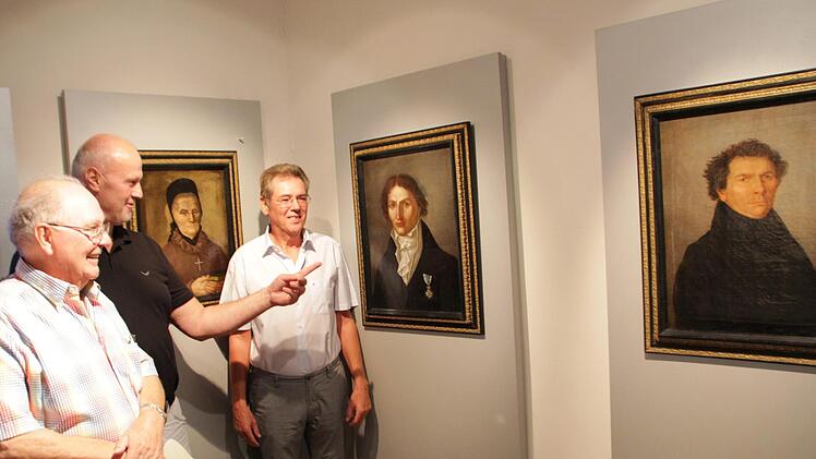 Sebastian Schmidt, Gerald Brehm und Herbert Fiederling (von links) freuen sich über die Porträts aus der Familie Spix im Heimatmuseum. Die Bilder zeigen von rechts: Jakob Spix, Johann Baptist von Spix und ihre Mutter Franziska. Foto: Andreas Dorsch