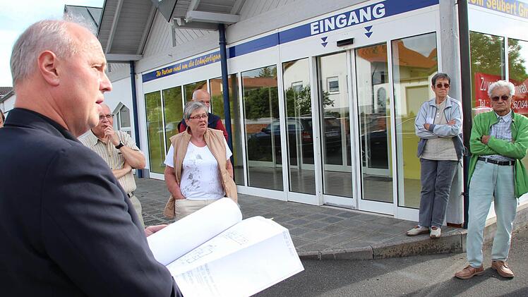 Bürgermeister Gerald Brehm (links) diskutierte mit Anwohnern die Pläne für das Areal, auf dem noch der ehemalige Lebensmittelmarkt steht. Foto: Andreas Dorsch