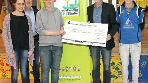 Die Schülersprecher Laetitia Weiß, Jannik Köhler und Markus Püls übergaben die Spenden an den Vorsitzenden der Stiftung für krebskranke Kinder, Uwe Rendigs (Zweiter von rechts). Schulleiter Wolfgang Fischer (Zweiter von links) zeigte sich stolz.  Foto: Michael Stelzner