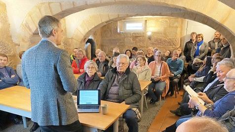 Der Vorsitzende des Stiftungsrats des Adalbert-Raps-Stiftung, Frank Kühne (stehend am Tisch), erläutert den interessierten Besuchern die Planungen für den "Heinersreuther Hof". Foto: Werner Reißaus