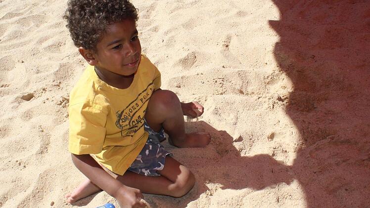 Benjamin spielt im Sand.