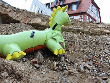 Weil die Baugrube vor der Kirche in Escherndorf verfüllt wird, muss Nessie gehen. Der kleine Drache machte den Anblick des unschönen Lochs ein wenig erträglicher. Foto: Pfannes