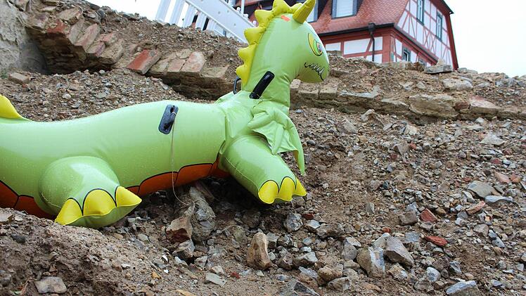 Weil die Baugrube vor der Kirche in Escherndorf verfüllt wird, muss Nessie gehen. Der kleine Drache machte den Anblick des unschönen Lochs ein wenig erträglicher. Foto: Pfannes