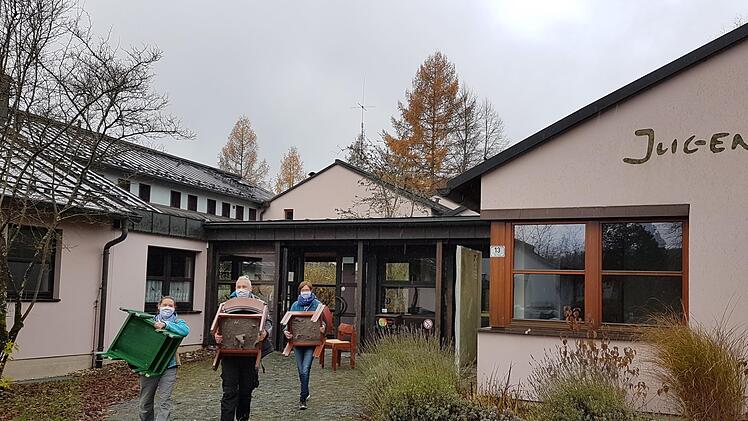 Die Mitarbeiter der Evangelischen Jugendbildungsstätte in Neukirchen (von links) Conny Brandl aus der Verwaltung, Hausmeister Stefan Moser und Pädagogin Ulrike Baetjer tragen letzte Stühle aus dem Haus. Foto: privat