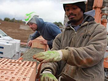 Misganu Bekele und sein Lehrlingskollege Yannick Roth verbauen die letzten Steine für die Garage. Acht Azubis bauen in Burglauer ein Haus - allein. Das Projekt soll den Auszubildenden Mut machen. Foto: Carmen Schmitt
