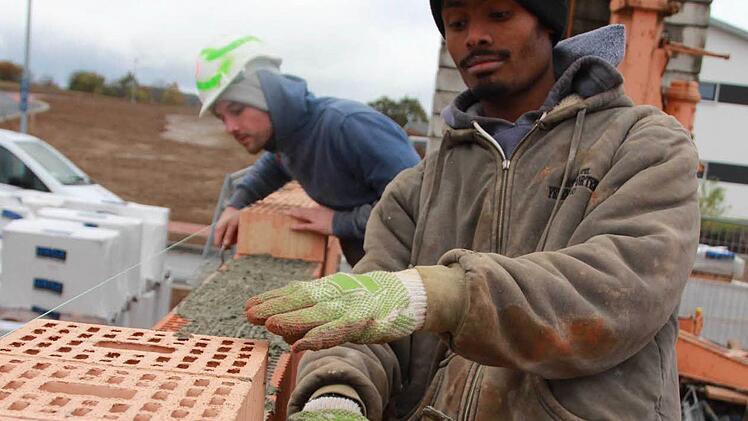 Misganu Bekele und sein Lehrlingskollege Yannick Roth verbauen die letzten Steine für die Garage. Acht Azubis bauen in Burglauer ein Haus - allein. Das Projekt soll den Auszubildenden Mut machen. Foto: Carmen Schmitt