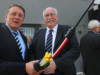 Oberbürgermeister Henry Schramm (CSU, links) und Regierungspräsident Wilhelm Wenning zeigen ein Glasfaserkabel, wie es im Industriegebiet verlegt wird. Fotos: Jürgen Gärtner