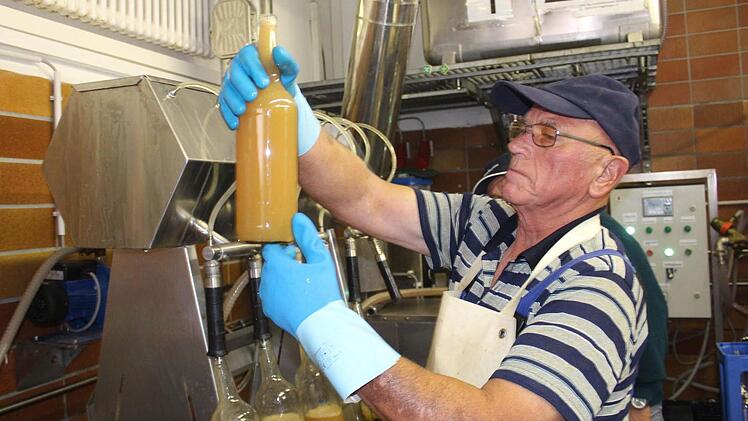 Lorenz Holbeck füllt den Saft in Flaschen ab. Seit vergangener Woche läuft die Presse in der Mosterei des Obst- und Gartenbauvereins in der Oberen Brauhausgasse in Höchstadt wieder. Foto: Sabine Herteux