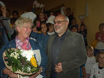 Allseits geschätzt: Reinigungskraft Adelinde Kaiser bei ihrer Verabschiedung mit Bürgermeister Franz Kuhn, im Hintergrund die Kinder, die mit den Lehrkräften ein Abschiedslied sangen. Foto: Stefan Geiger