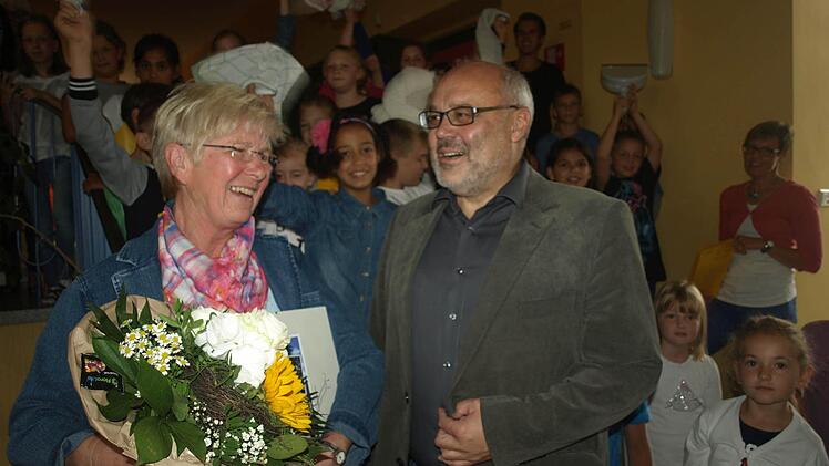 Allseits geschätzt: Reinigungskraft Adelinde Kaiser bei ihrer Verabschiedung mit Bürgermeister Franz Kuhn, im Hintergrund die Kinder, die mit den Lehrkräften ein Abschiedslied sangen. Foto: Stefan Geiger