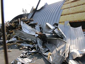 Am Tag nach dem Brand der Freizeithalle am goldenen Feld türmt sich vor dem Gebäude abgerissenes Material aus der Dachkonstruktion. Foto: Jürgen Gärtner