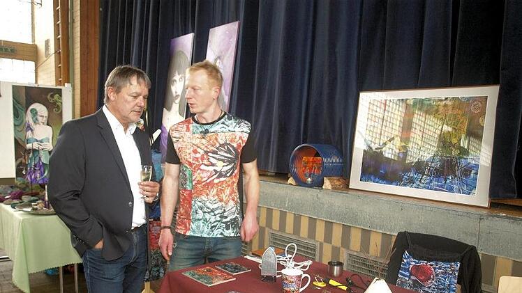 Bürgermeister Gerhard Wunder lässt sich von Frank  Rehwald die Enkaustik-Technik erklären. Foto: Susanne Deuerling