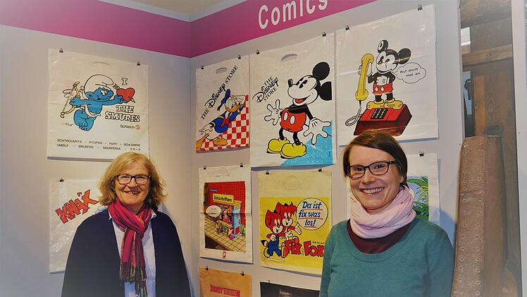Museumschefin Regina Hanemann (links) und Kuratorin Johanna Blume mit einigen Beispielen von besonderen Tüten.