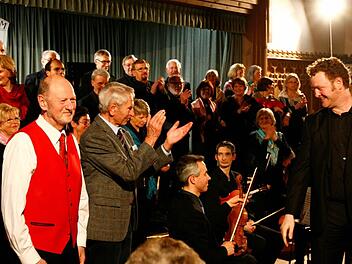 Die Helden des Abends: Der Komponist der "Fränkischen Weihnacht, Karl Haus, applaudiert dem Dirigenten des Forchheimer Liedervereins Jens Birnbach; Autor Reinhold Schmitt (rote Weste). Fotos: Neubauer