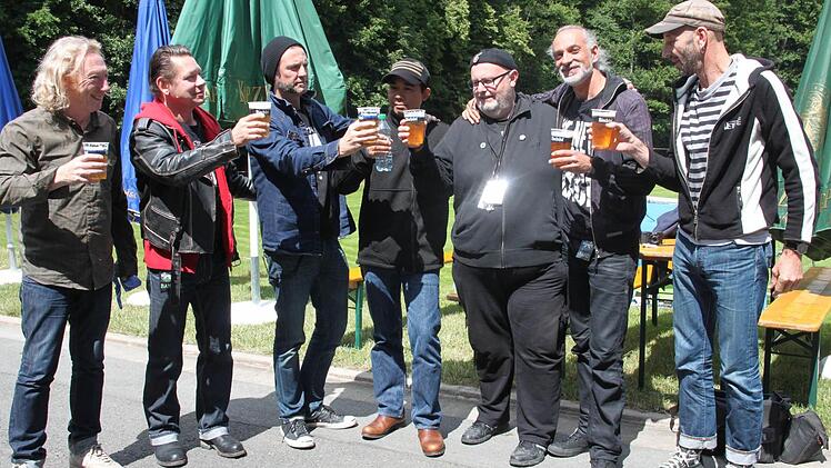 Stießen auf ein gutes Gelingen an: Brandy Schäck (Dritter von rechts) und die Mitglieder der Berliner Band "Der stille Kommandeur" mit (von links) Sänger und Gitarrist Harry Coltello, Bassist Christoph Frenz, Schlagzeuger Steve Hahn, Manager Thawa, Schlagzeuger Markus Köstner und Gitarrist Sepp Ehrensberger. Foto: Stephan Stöckel