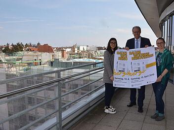 Simira Tang, Bürgermeister German Hacker und Mignon Ramsbeck-Ullmann (von links) werben für den Besuch der Stadtmesse. Im Hintergrund die Großbaustelle der ehemaligen Puma-Verwaltung in der Würzburger Straße, wo rund einhundert Wohnungen entstehen. Bauen und Renovieren bedeutet auch immer Klimaschutz. Foto: Bernhard Panzer