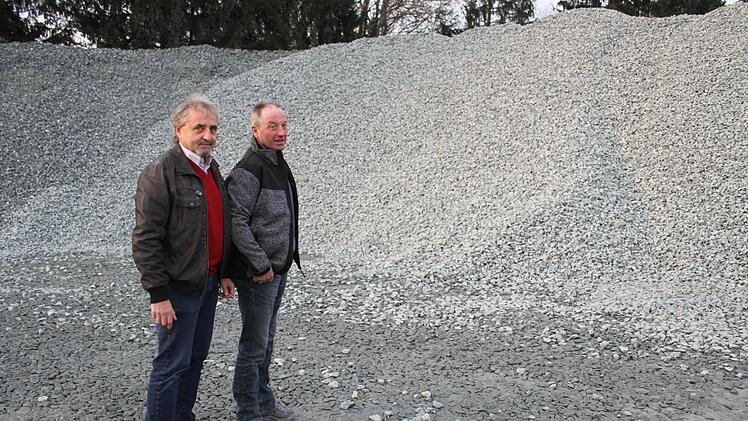 Verkaufsleiter bei den Hartsteinwerken Schicker Bernhard Herold und Betriebsleiter Oswin Kirchner vor einem Mega-Berg Bahnschotter. Bahnschotter muss eine besondere Körnung haben und muss besonders hart sein.