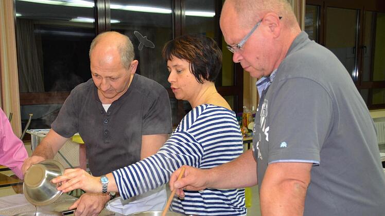 - Kursleiterin Corinna Raab erklärt Karl Voll (links) die Zubereitung eines Schokopuddings. Daneben rührt Jaak Smits in einem Topf mit Milchreis, damit dieser nicht anbrennt. Foto: Kathrin Kupka-Hahn