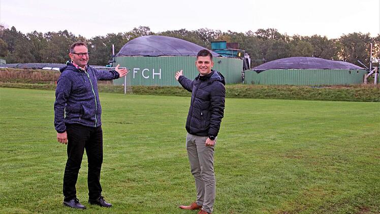 Da kommt die Wärme her: Landwirt Holger Gundermann (links) und FCH-Vorsitzender Simon Weber vor der Biogasanlage, die das Sportheim Haarbrücken versorgt. Foto: Peter Tischer