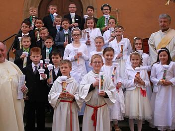 Ebern &mdash; Pater Rudolf Theiler (links) und Diakon Uwe Holschuh (rechts) begleiteten in Ebern 25 Kinder erstmals zum Tisch des Herrn. Die 16 Jungen und neun M&auml;dchen empfingen in einem Gottesdienst in der Stadtpfarrkirche zum ersten Mal den Leib des Herrn. Foto: Katharina Becht