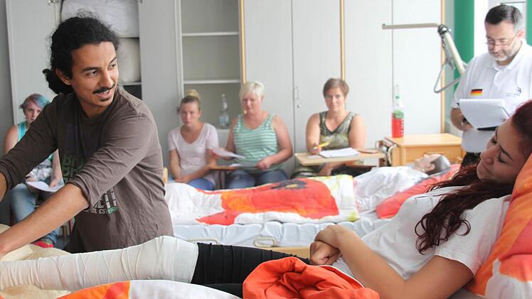 Mohammad Reza Nikbin hilft der "Patientin" unter den strengen Blicken der Jury aus dem Bett.  Fotos: Ralf Dieter