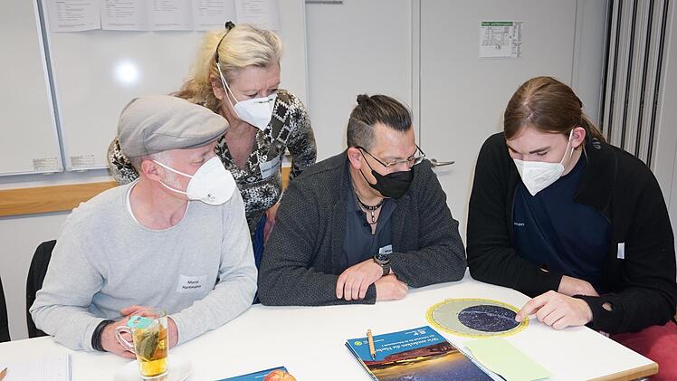 Der Sternenhimmel wird anhand einer Sternenkarte mit dem Vorstandsvorsitzenden des Vereins Sternenpark Rhön, Simon Manger (rechts), kennengelernt. Mit im Bild: (von links) Mario Hartmann (Fulda), Moni Powers (Haunetal) und Marcus Göttlich (Haunetal). Foto: Marion Eckert