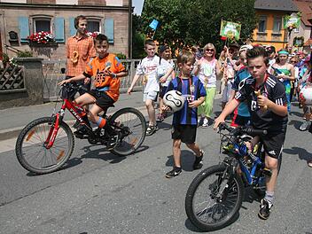 Doppelt gemoppelt hält besser: Die Fußball-Fans tragen nicht nur ein Fußballtrikot, sondern kommen auch noch mit einem Rad. Fotos: Sonja Adam