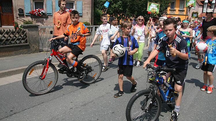 Doppelt gemoppelt hält besser: Die Fußball-Fans tragen nicht nur ein Fußballtrikot, sondern kommen auch noch mit einem Rad. Fotos: Sonja Adam