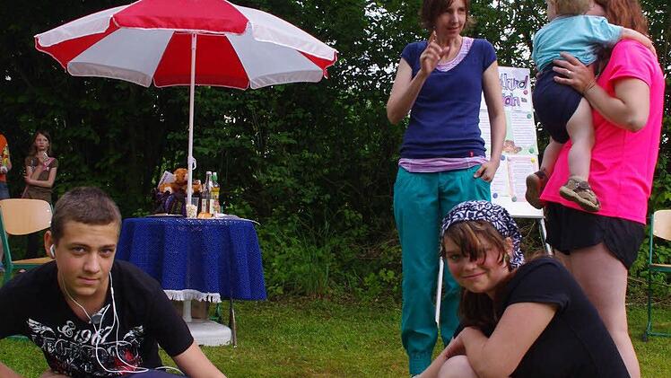 Alex und Janine (vorne, von links) streicheln Deliah. Im Hintergrund ist Deliahs "Frauchen" Jana Hofmann im Gespräch mit interessierten Eltern zu sehen. Foto: Heike Schülein