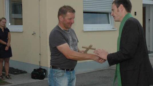 Pfarrer Peter Bauer (rechts) überreicht an Bauhofleiter und Klärwärter Manfred Schirdewahn ein Kreuz. Foto: Gerhard Schmidt
