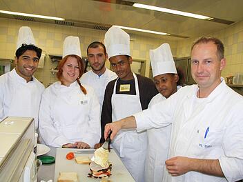Wenn Fachlehrer Markus Bötz (rechts) mit Asylbewerbern wie Omidreza Fayzeyab (links) oder Kumengr Getahun Mulesa (2. von rechts) ein Sandwich zubereitet, dann geht es weniger um ausgefeilte Kochkünste als um Vokabeln und den Umgang mit der deutschen Sprache. Fotos: Ralf Ruppert