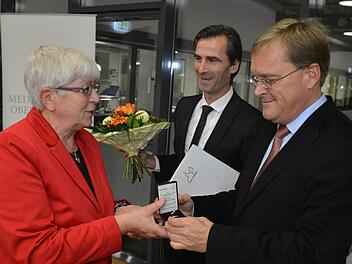 Von Oberbürgermeister Andreas Starke (rechts) bekam Rosemarie Rößler die Bürgernadel, von Philipp Magnus Froben (links) gab es einen Blumenstrauß und die Urkunde.   Fotos: Ronald Rinklef