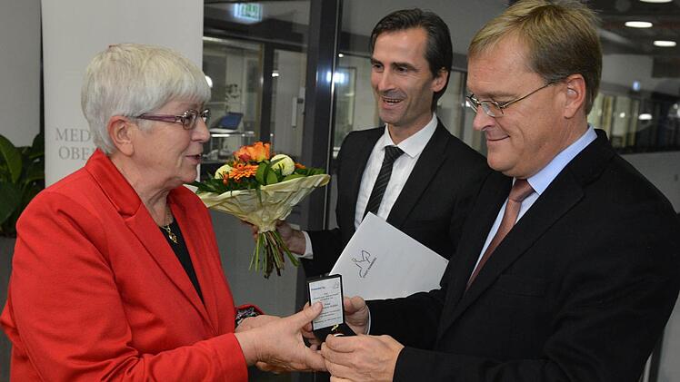 Von Oberbürgermeister Andreas Starke (rechts) bekam Rosemarie Rößler die Bürgernadel, von Philipp Magnus Froben (links) gab es einen Blumenstrauß und die Urkunde.   Fotos: Ronald Rinklef