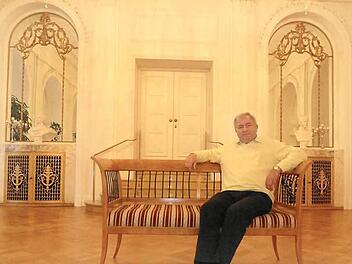Albin Markert, der den Beruf des Polsterers lernte, bevor er Kurwart wurde, hat im Weißen Saal auf einer Bank Platz genommen.  Foto: Thomas Ahnert