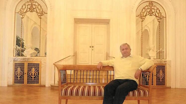 Albin Markert, der den Beruf des Polsterers lernte, bevor er Kurwart wurde, hat im Weißen Saal auf einer Bank Platz genommen.  Foto: Thomas Ahnert
