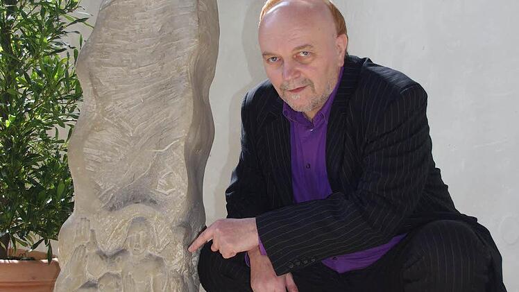 Bernd Graf erläutert in der Christuskirche Kronach die Begegnung des zunächst ungläubigen Thomas mit dem auferstandenen Christus, die Heinrich Schreiber auf dem Osterleuchter (1988) dargestellt hat.  Foto: Heike Schülein