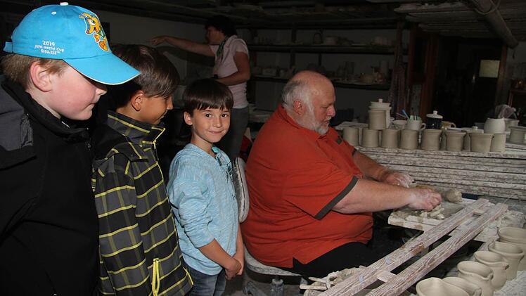 Die Jungs schauen Friedrich Sommer von der Töpferei Renner über die Schulter.