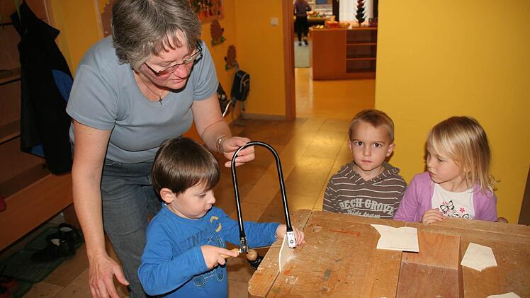 Der vierjährige Luca sägt  mit Eifer, die Erzieherin Gabi Hutzler hilft ihm dabei.Foto: fra-press
