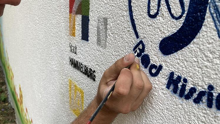 Für Details wie dem Logo der Stadt Hammelburg oder des Kreisjugendrings greift selbst Künstler Thorsten Grützmann zum Pinsel. Foto: Ralf Ruppert