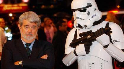 George Lucas - hier mit einem "Sturmtrooper" bei der Premiere zum Film "Die Rache der Sith" -  hat "Lucasfilm" an Disney verkauft. Foto: Richard Lewis/dpa/Archiv