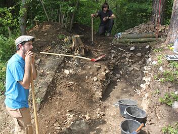 Die Archäologen Konstantin Teichmann (links) und Philipp Schinkel bei der Arbeit: Rechts und links neben dem Weg haben sie durch Stichgrabungen nachgewiesen, dass exakt an dieser Stelle ein Tor zur keltischen Stadt gestanden haben muss. Warum es zerstört wurde, ist jedoch unklar. Foto: Matthias Einwag