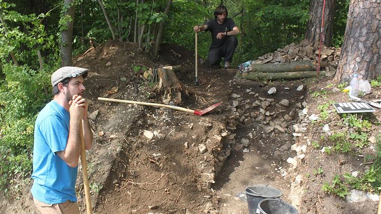 Die Archäologen Konstantin Teichmann (links) und Philipp Schinkel bei der Arbeit: Rechts und links neben dem Weg haben sie durch Stichgrabungen nachgewiesen, dass exakt an dieser Stelle ein Tor zur keltischen Stadt gestanden haben muss. Warum es zerstört wurde, ist jedoch unklar. Foto: Matthias Einwag