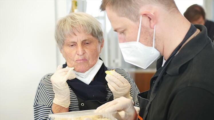 Ortrud und Marcel überlegen, ob das Gericht, das sie aus einer Kantine bekommen haben, vegetarisch ist.
