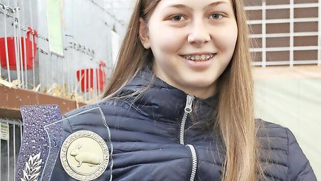 Luisa Boßecker freut sich dass, sie für ihre Zucht mit Deutschen Kleinwidder-Kaninchen wildfarben mit dem den Jugend-Ehrenpreis ausgezeichnet wurde.